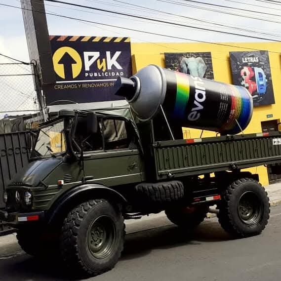 Lata gigante de pintura Evans sobre un camión, frente al local de PyK