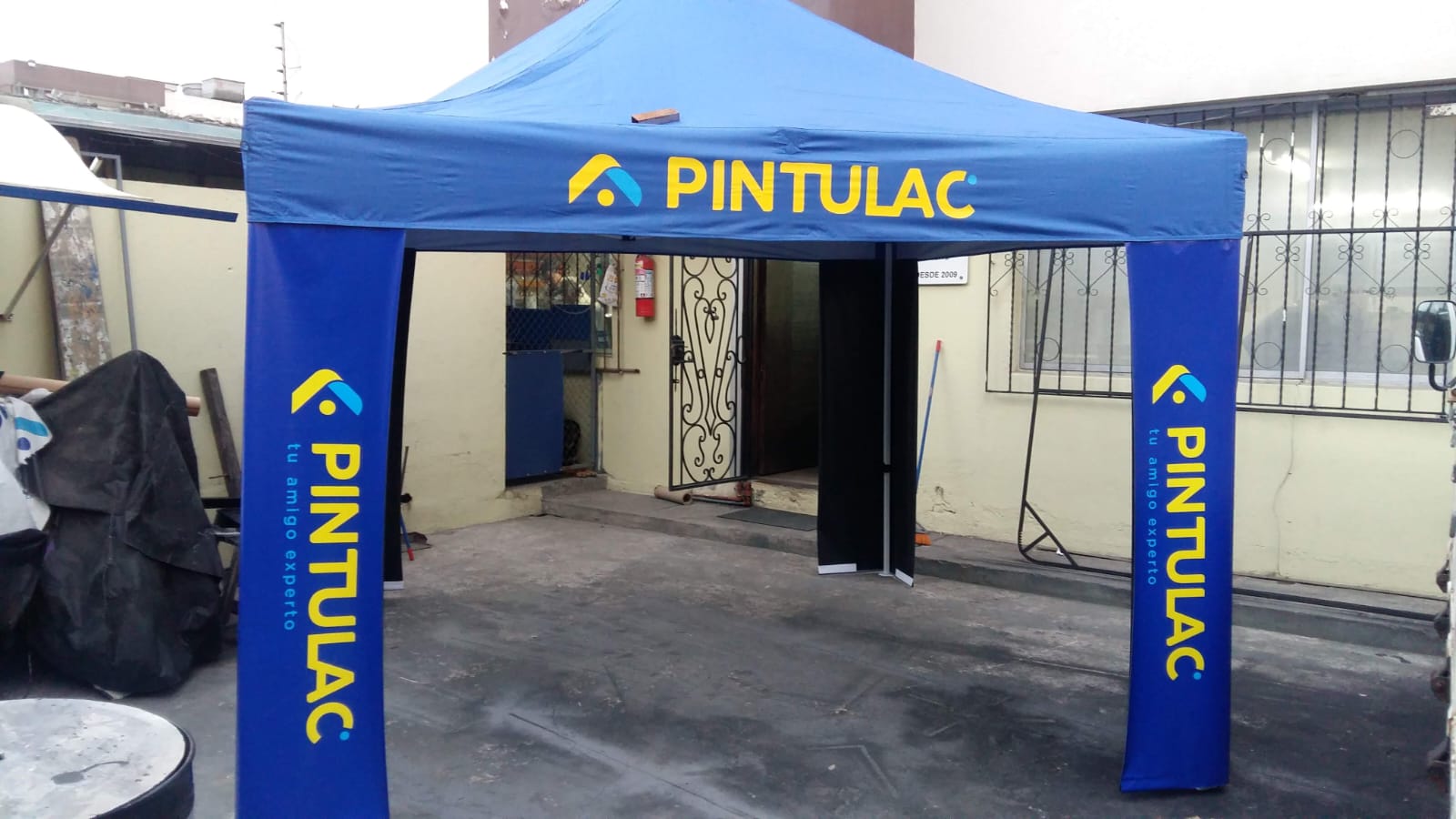 Carpa azul de Pintulac con el logo impreso en el techo y fundas en las patas