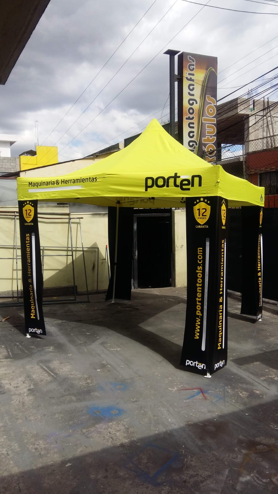 Carpa amarilla de Porten Maquinaria y Herramientas con fundas negras en las patas