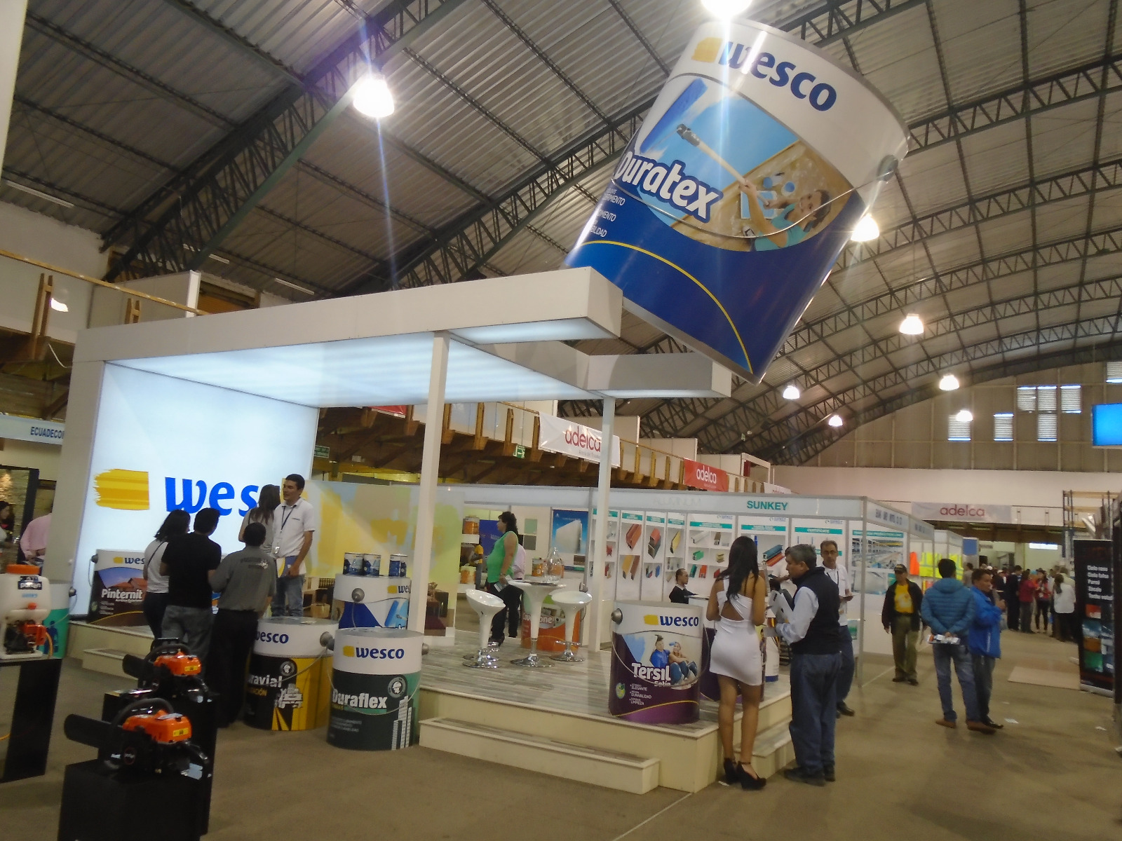 Stand de pinturas Wesco en una feria, con un galón gigante de Duratex colgado sobre el stand
