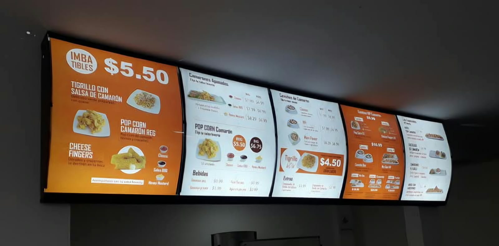 Menu board iluminado de cinco paneles curvos con los platos y precios de Imbatibles