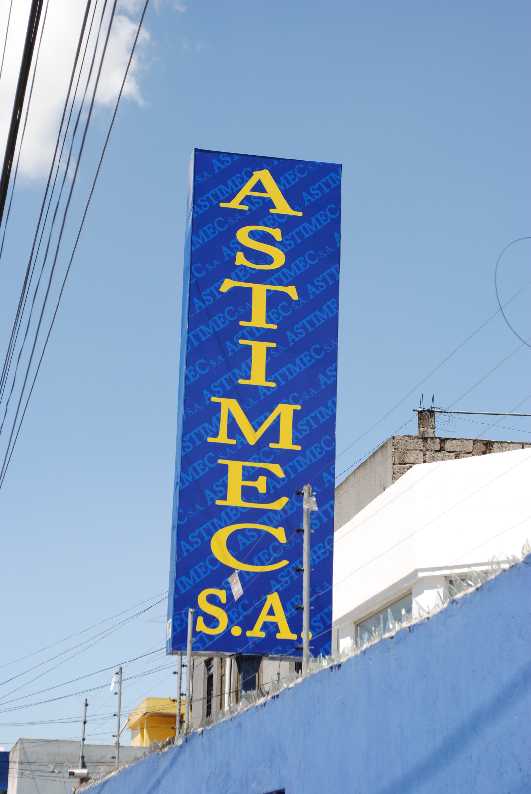 Monolito alto azul con letras amarillas de Astimec S.A.