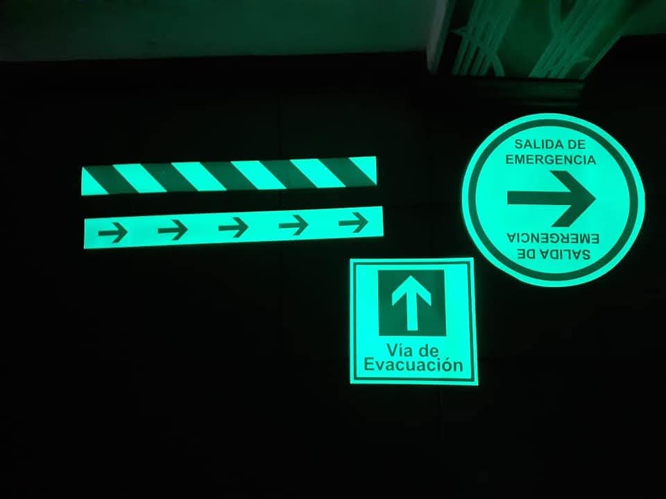 Señales fotoluminiscentes de salida de emergencia, vía de evacuación y cintas de seguridad en la oscuridad