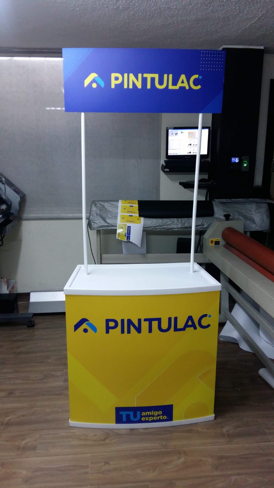 Counter promocional de Pintulac con frente amarillo y letrero azul arriba